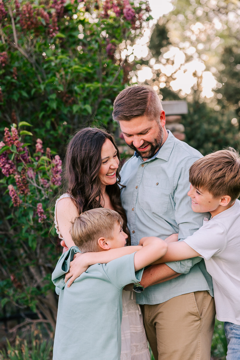 Family hugging in front of flowers
